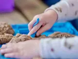 Een kind speelt met wat zand