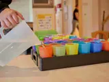 Een begeleider schenkt limonade in voor de kinderen